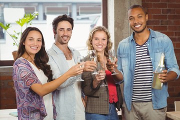 Portrait of business people toasting with champagne in office 