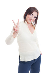 Casual woman showing victory or peace gesture and smiling