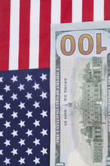 One hundred Dollar bill on American flag