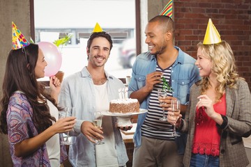 Portrait of smiling businessman holding cake during birthday 
