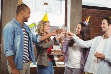Happy colleagues toasting with champagne in office 