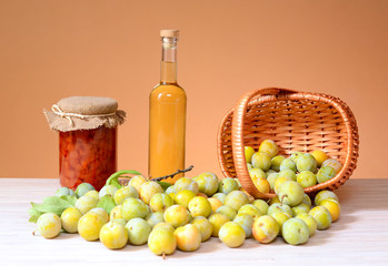 Brandy and plums with a jar of jam on a table