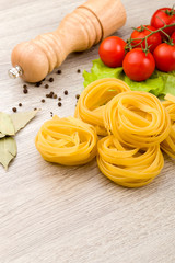 Pasta, tomatoes and pepper on a wooden background