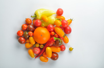Fresh colorful tomatoes for use as cooking ingredients on white background.