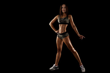 strong tanned beautiful sports girl on a black background. copy space.