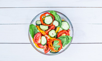 Fresh green salad on white wooden background