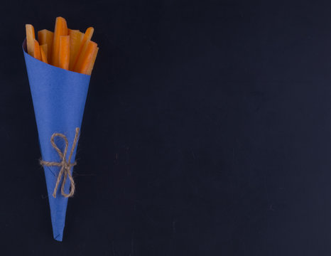 Carrot sticks in a blue lie from left. Blue bag tied with string