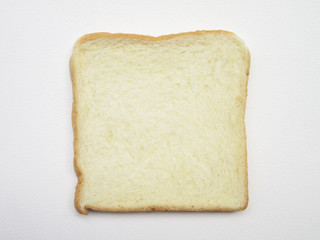 Close-up image of one slice of white bread against the paper white background