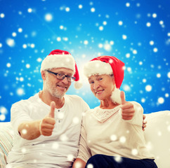 happy senior couple in santa helper hats