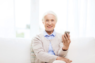 senior woman with smartphone at home