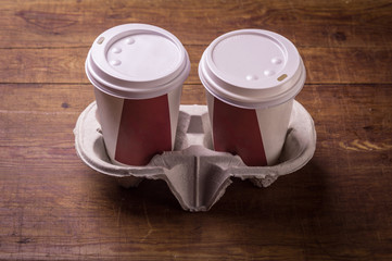 Paper cups of coffee on wood background