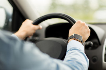 close up of man with wristwatch driving car