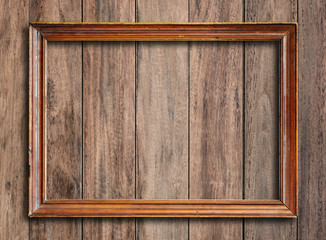 Old picture frame on vintage wood wall.