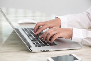 Closeup of business woman hand typing on laptop keyboard