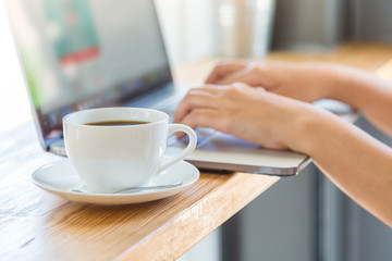 Coffee cup  with laptop on old wooden table