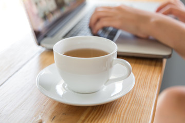 Coffee cup  with laptop on old wooden table