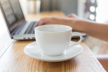 Coffee cup  with laptop on old wooden table