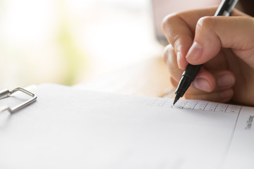 Hand with pen over application form