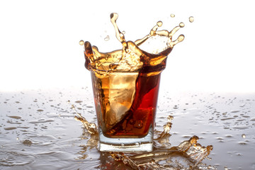 splashing out of the glass from falling ice cubes