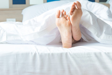 Close up of two feet in a bed.focus on feet