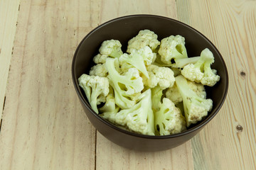 Prepared Cauliflower decorated in bowl over wooden background