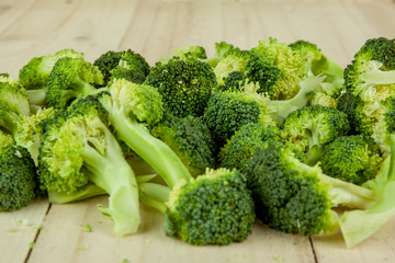 Fresh green broccoli on wooden cutting board close up