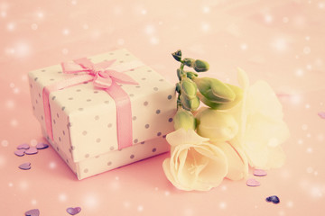 Beautiful little gift box and freesia flower on pink background