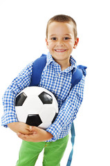 Happy young school boy holding a football