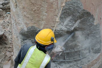 Construction workers using mobile concrete hacker at the construction site 