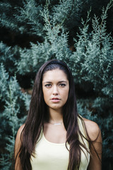 Portrait of a beautiful young woman with trees in background