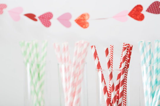 Colorful paper straws with a garland of hearts