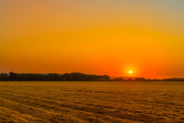 Fototapeta premium Sunrise over a countryside field