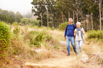 Senior couple walking in a forest towards the camera