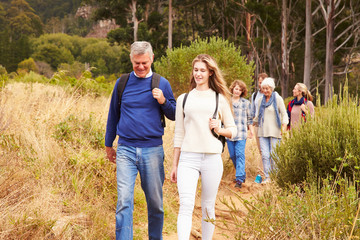 Multi-generation family walking together through a forest
