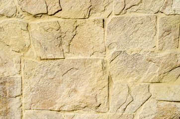 Yellow stone cladding plates on the wall