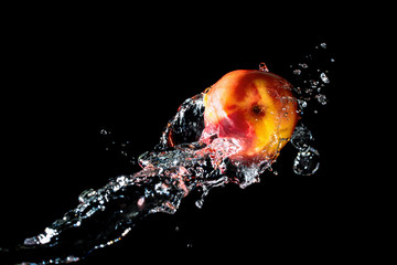 Fototapeta na wymiar Peach with fresh water splash against black background