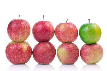 Green apple among red isolated on white background