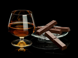 Chocolate and cognac in glassware it is isolated on black