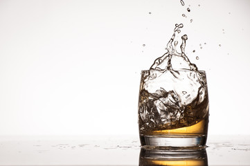 Ice splash into whiskey or brandy