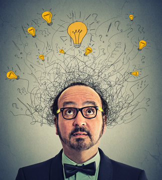 Thinking man with question signs and light idea bulbs above head looking up