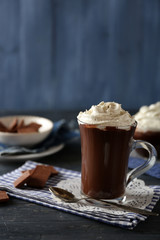Cups of coffee with cream on color wooden background