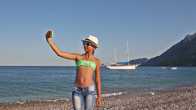 Young girl making a selfie on the beach of the Mediterranean Sea