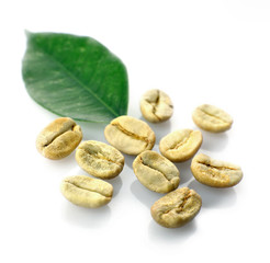 Heap of green coffee beans with leaf isolated on white