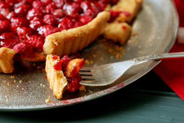 Piece of tart with raspberries on tray, close-up