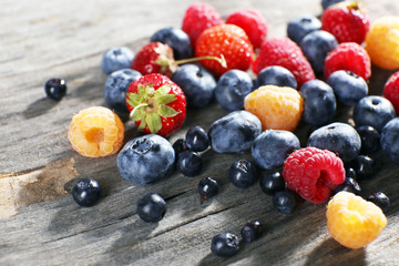 Heap of sweet tasty berries on wooden table close up