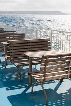 Wooden tables and benches on top deck of ferry. Malta, Gozo.