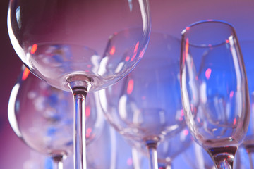 Empty wine glasses on color background