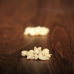 two piles of nine cashew nuts on wood - series