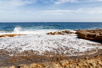 The waves beat against the rocky shore. 