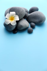 Naklejka na ściany i meble Spa stones with flower on blue background